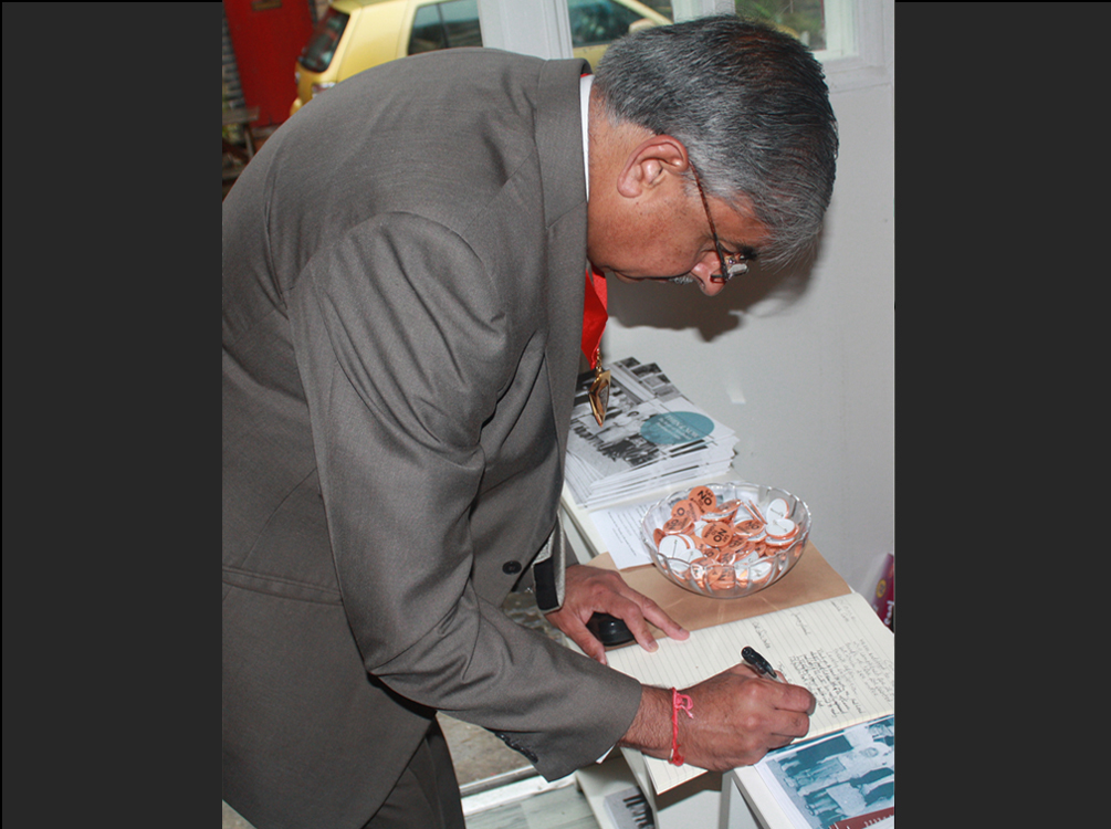 Signing the guestbook book at Then and Now event